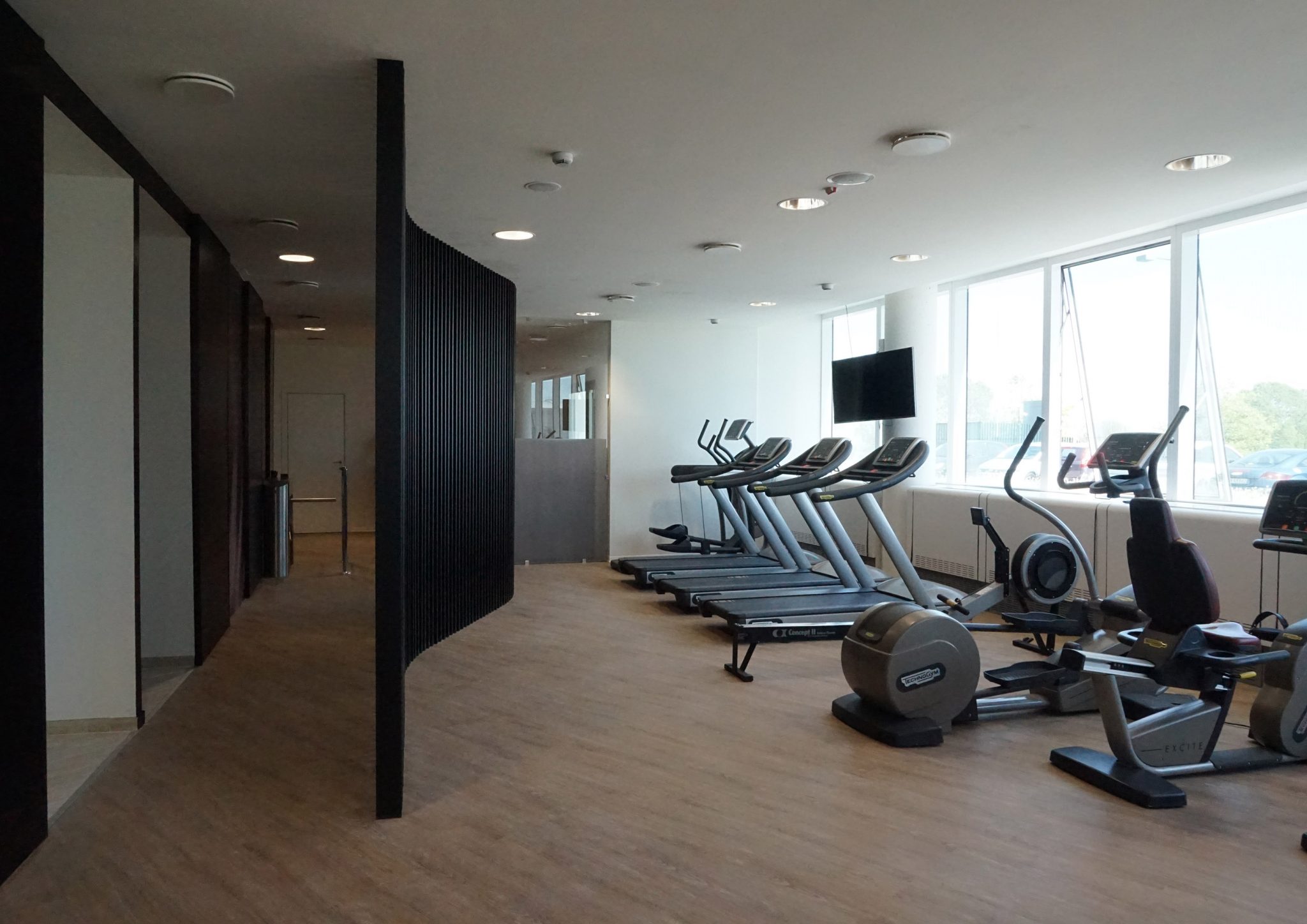 American Express Fitness Club, boiserie colore nero e macchine cardio Technogym