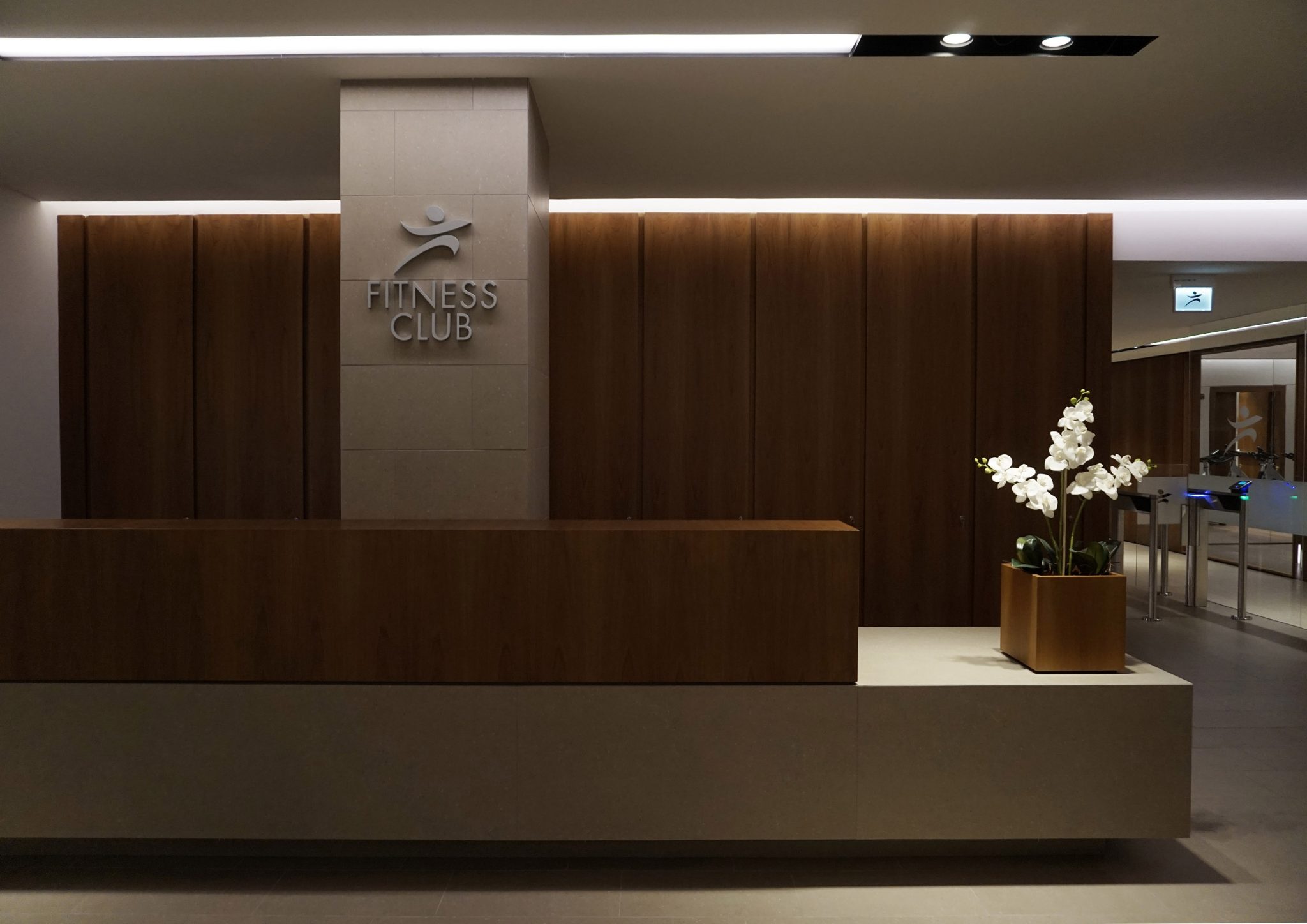 BPM Fitness Club, reception con desk in noce e pietra di Borgogna, boiserie in noce
