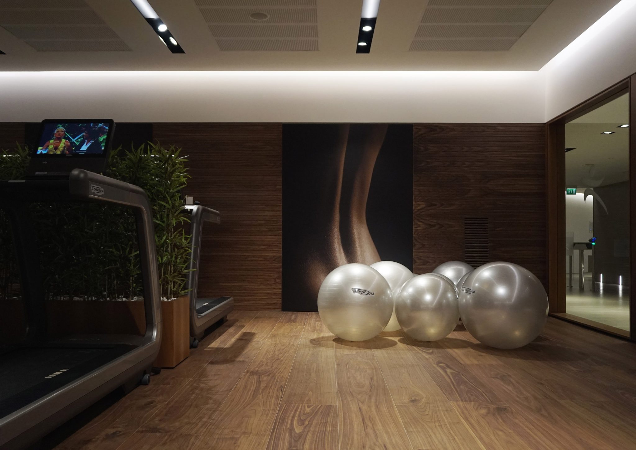 BPM Fitness Club, area cardio con rivestimento a pavimento e a parete in noce