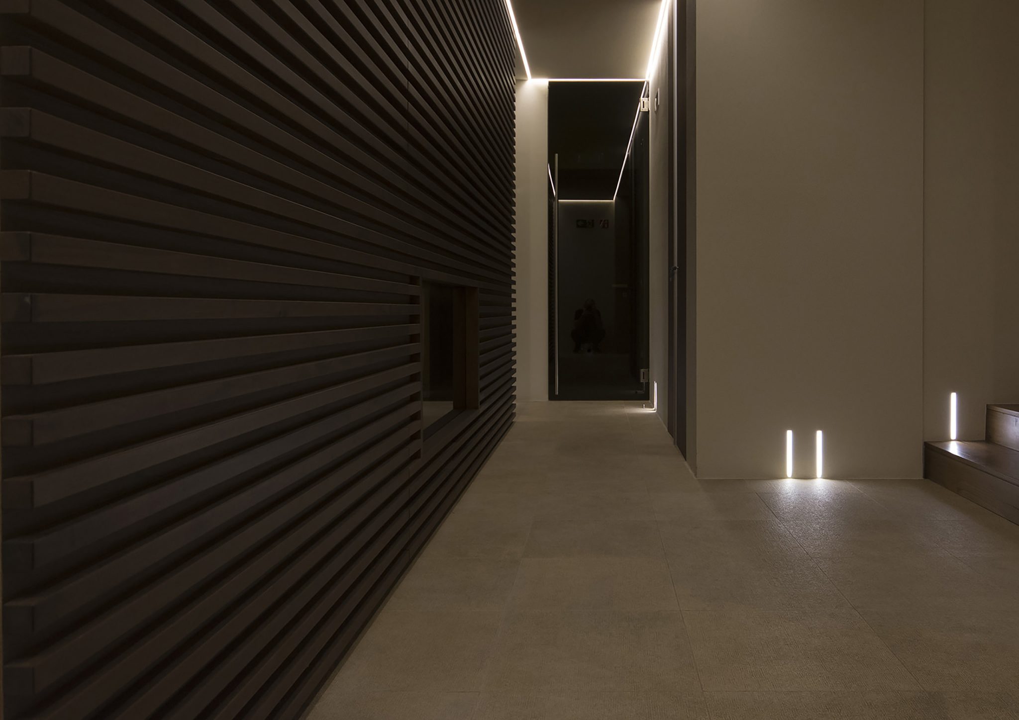 Borgo Cadonega Spa, ingresso con grande boiserie in rovere e illuminazione scenografica con faretti incassati e tripled nascoste