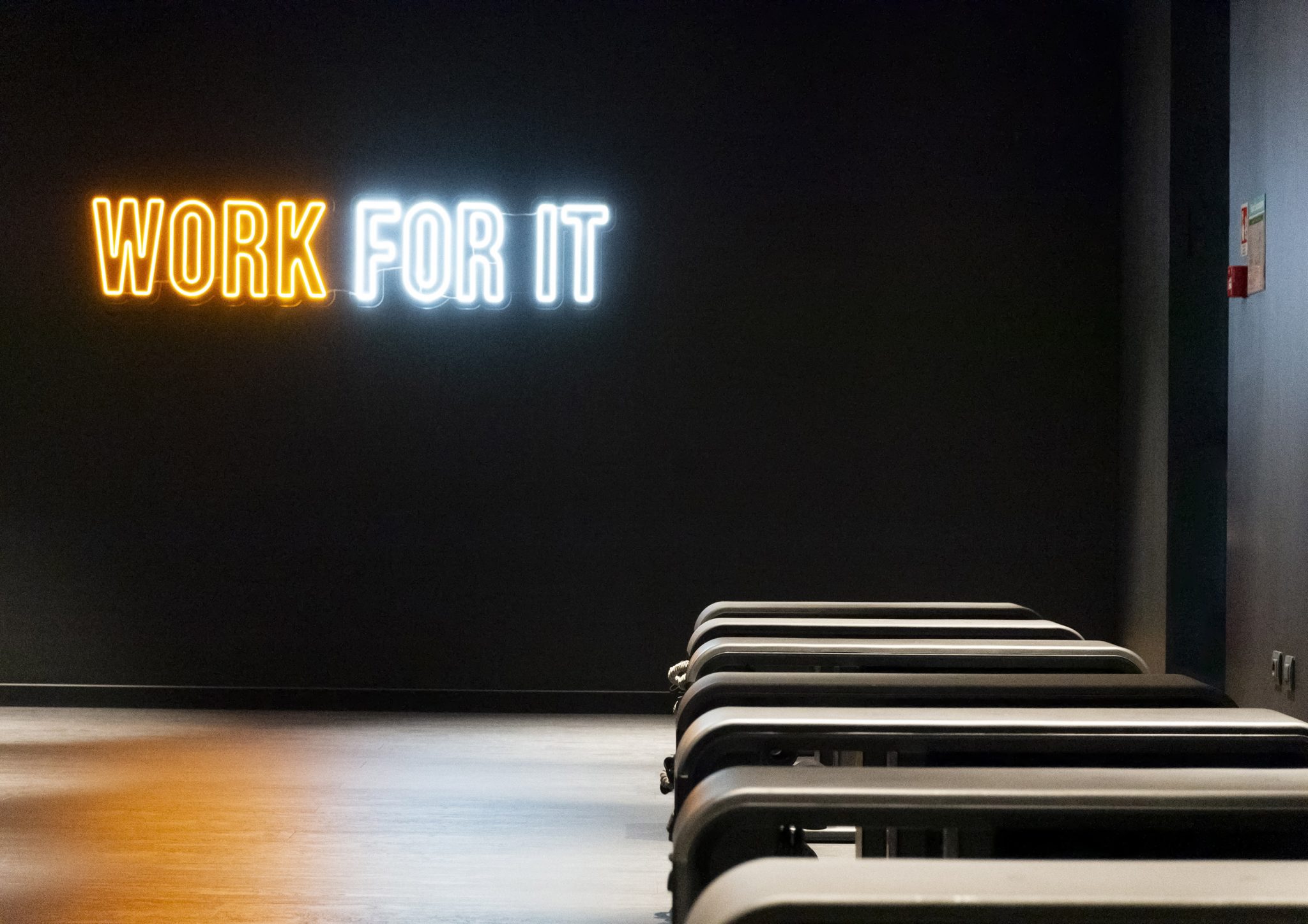 Storm Club, sala funzionale con Technogym Bench e scritta a led