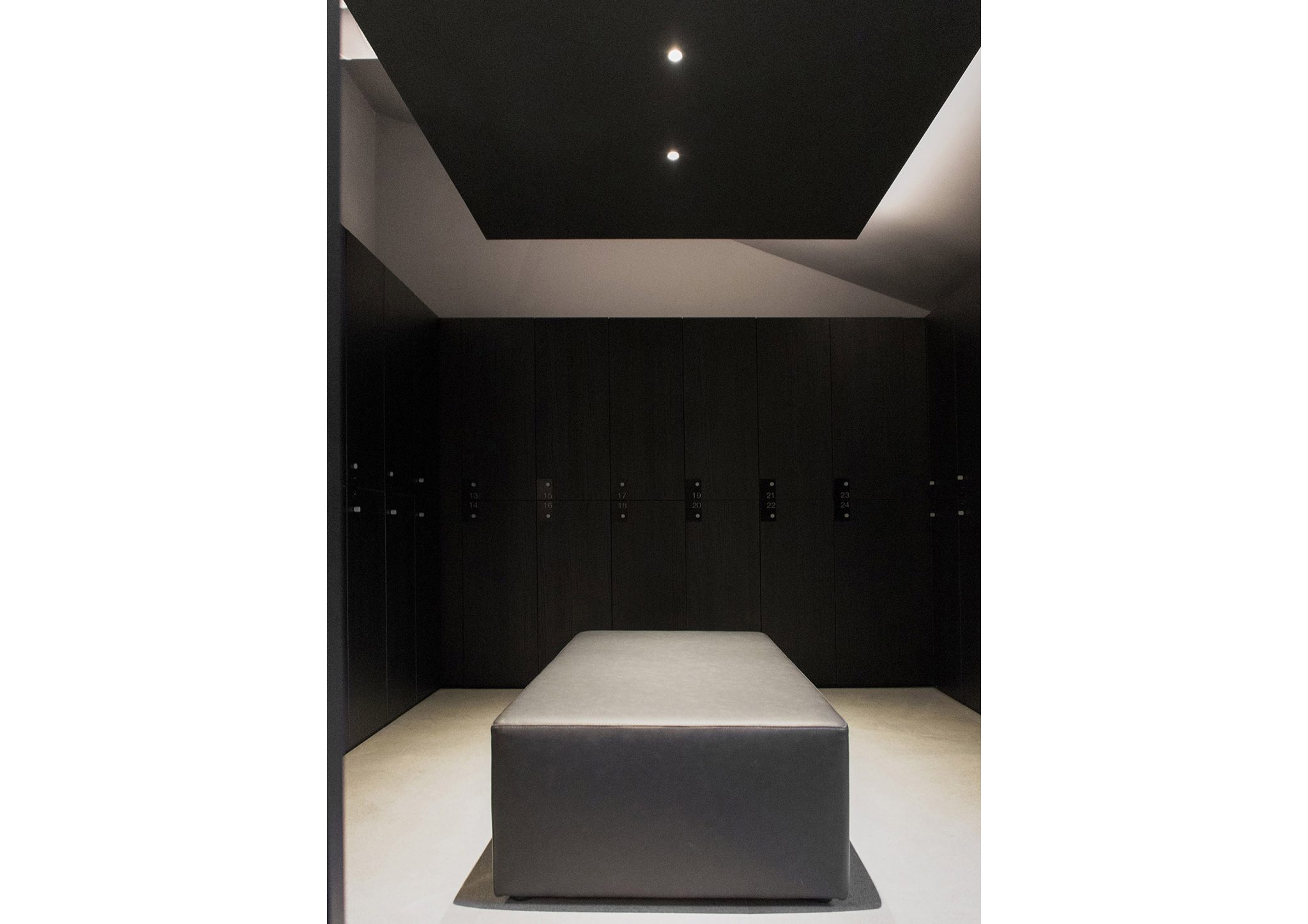 Storm Club, spogliatoi con armadietti finitura dark wood e puff centrale